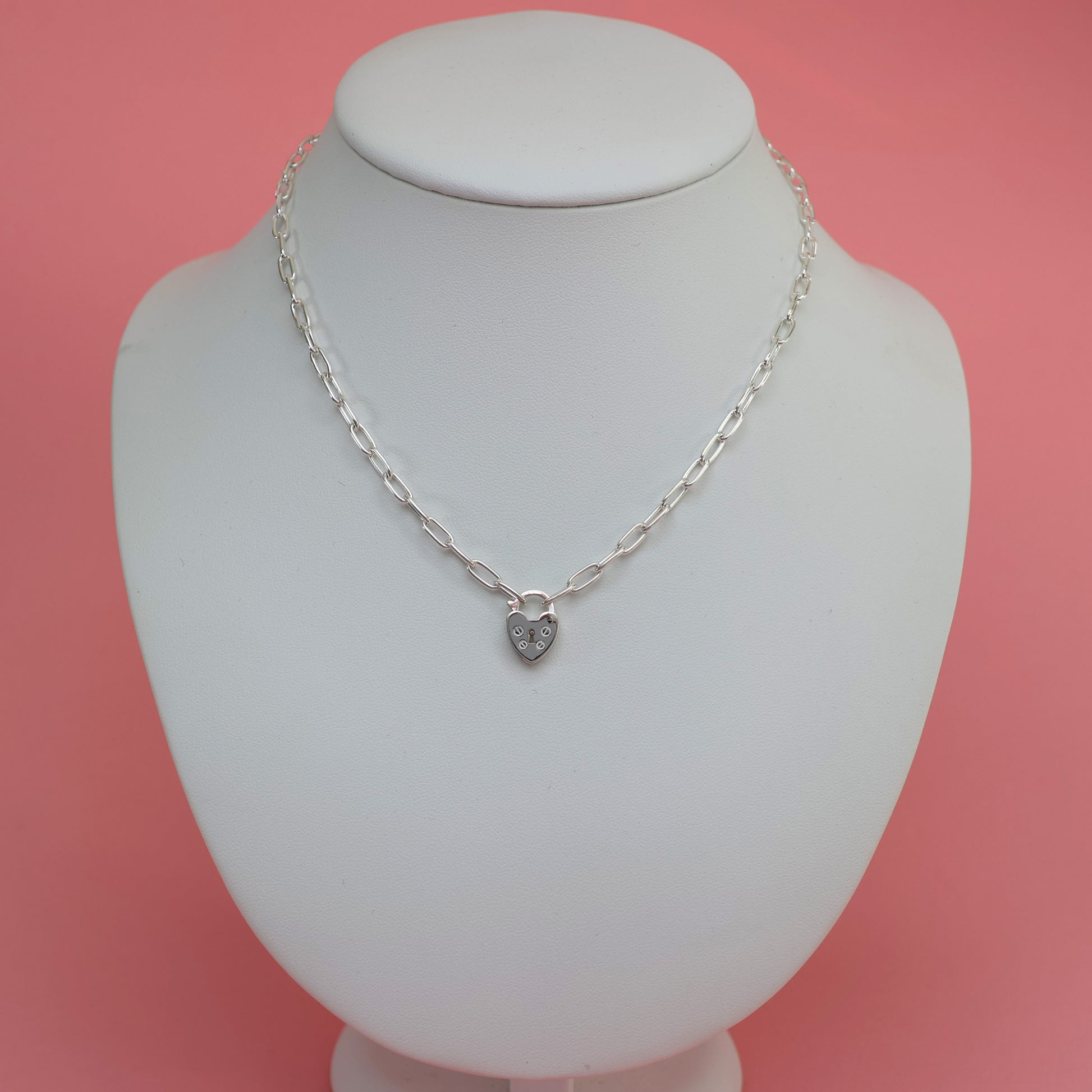 Stylish padlock clasp silver necklace displayed on a white jewelry stand