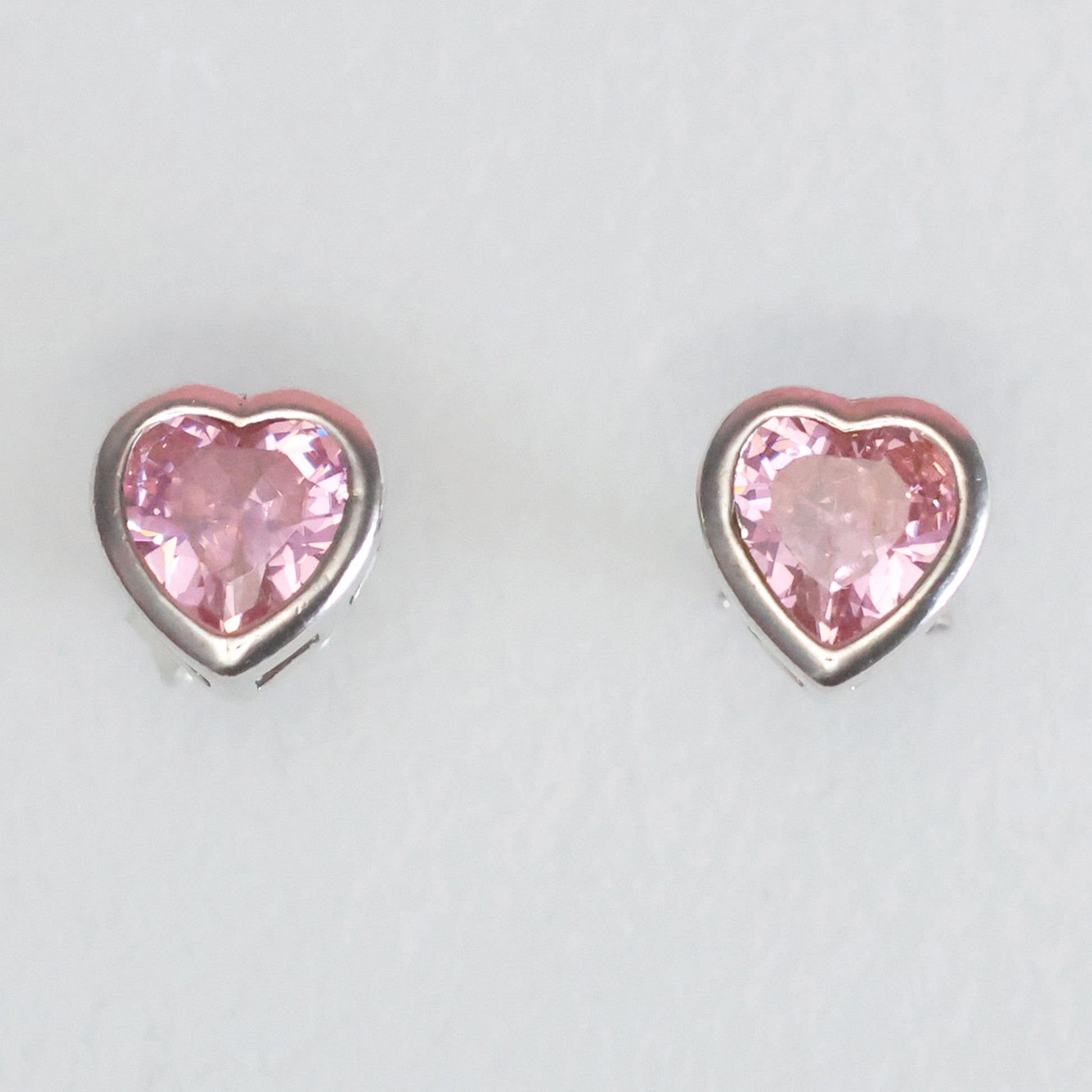 Heart-shaped pink gemstone stud earrings in silver setting for stylish elegance