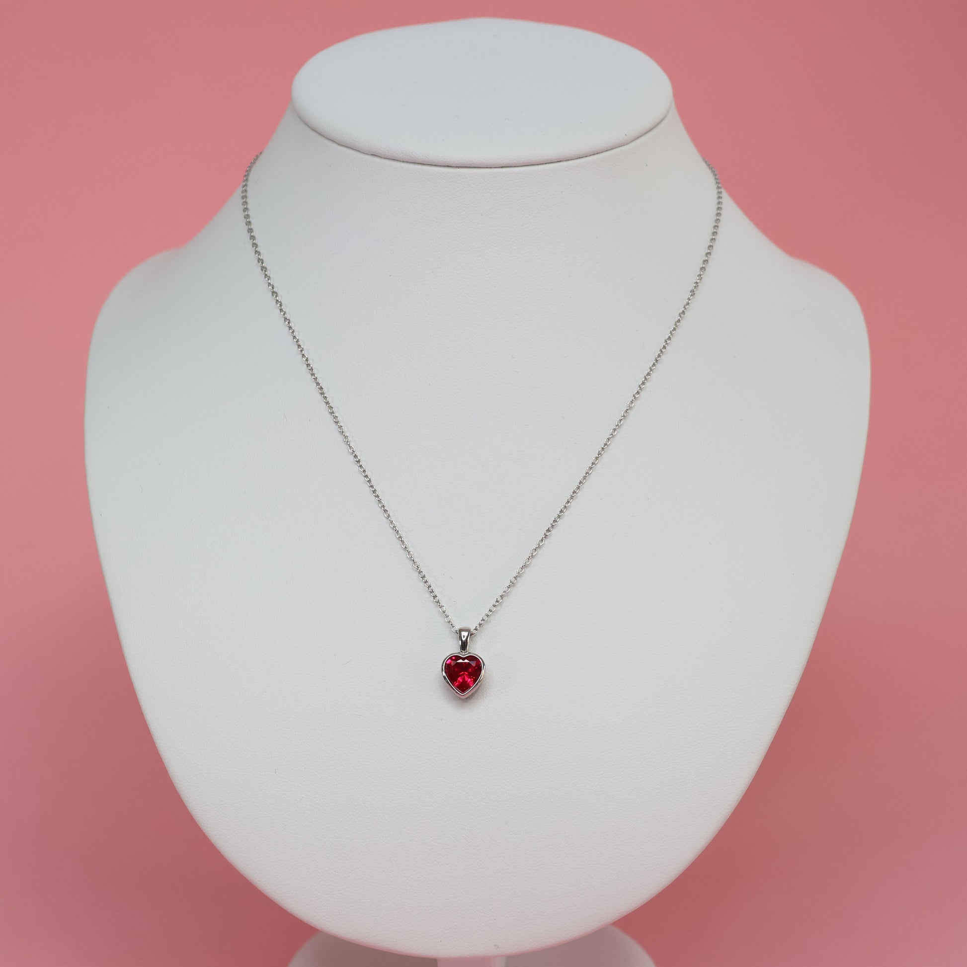 Stylish red heart cubic zirconia pendant on a silver chain displayed on a jewelry bust