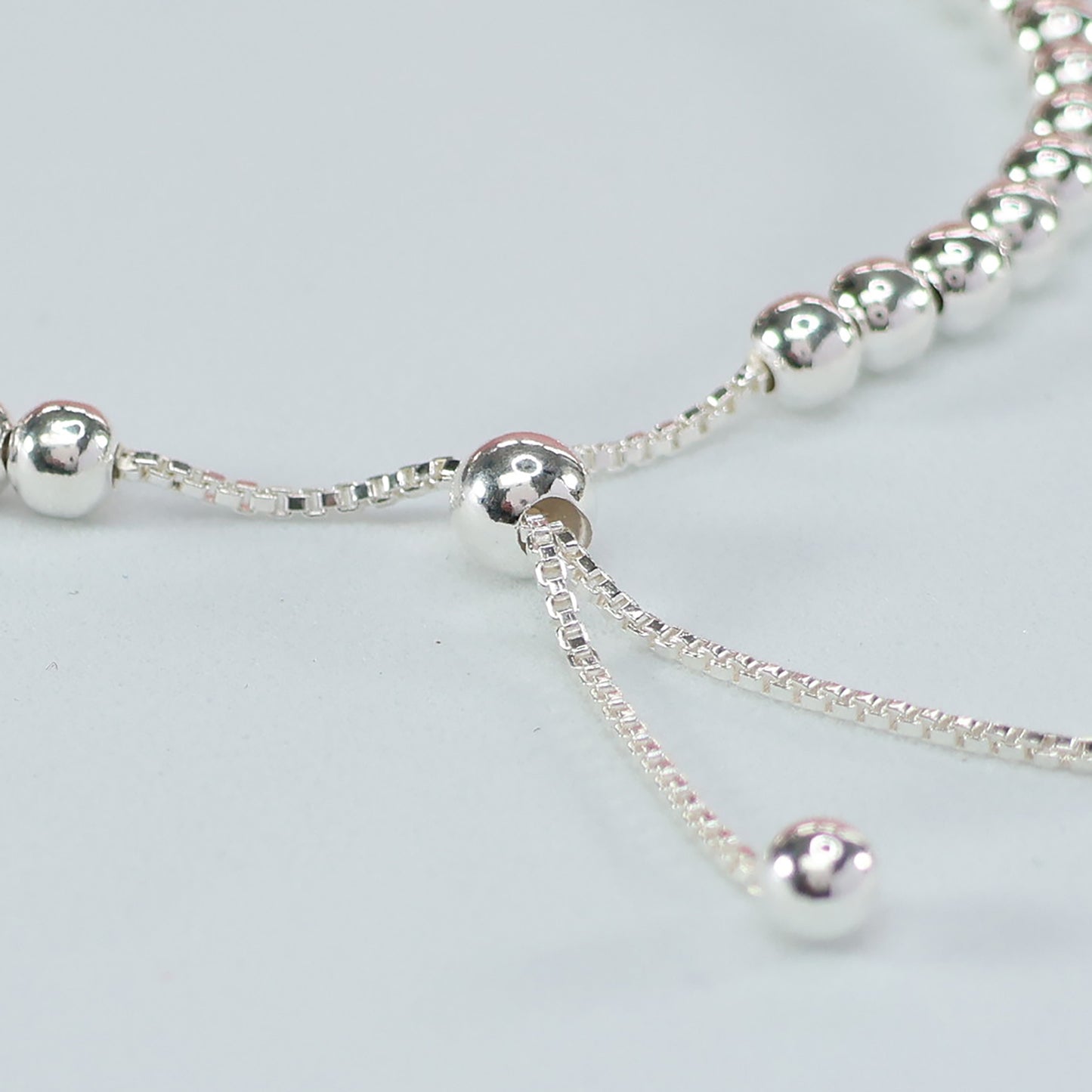 Elegant silver bead heart charm bracelet featuring shimmering silver beads and a delicate design
