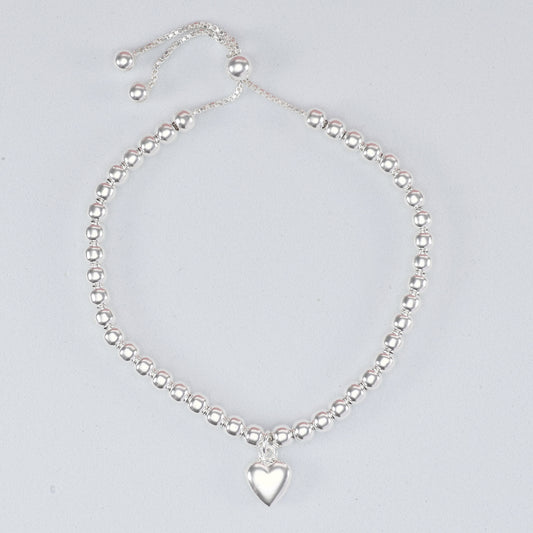 Silver bead heart charm bracelet featuring a polished heart pendant and adjustable sliding clasp