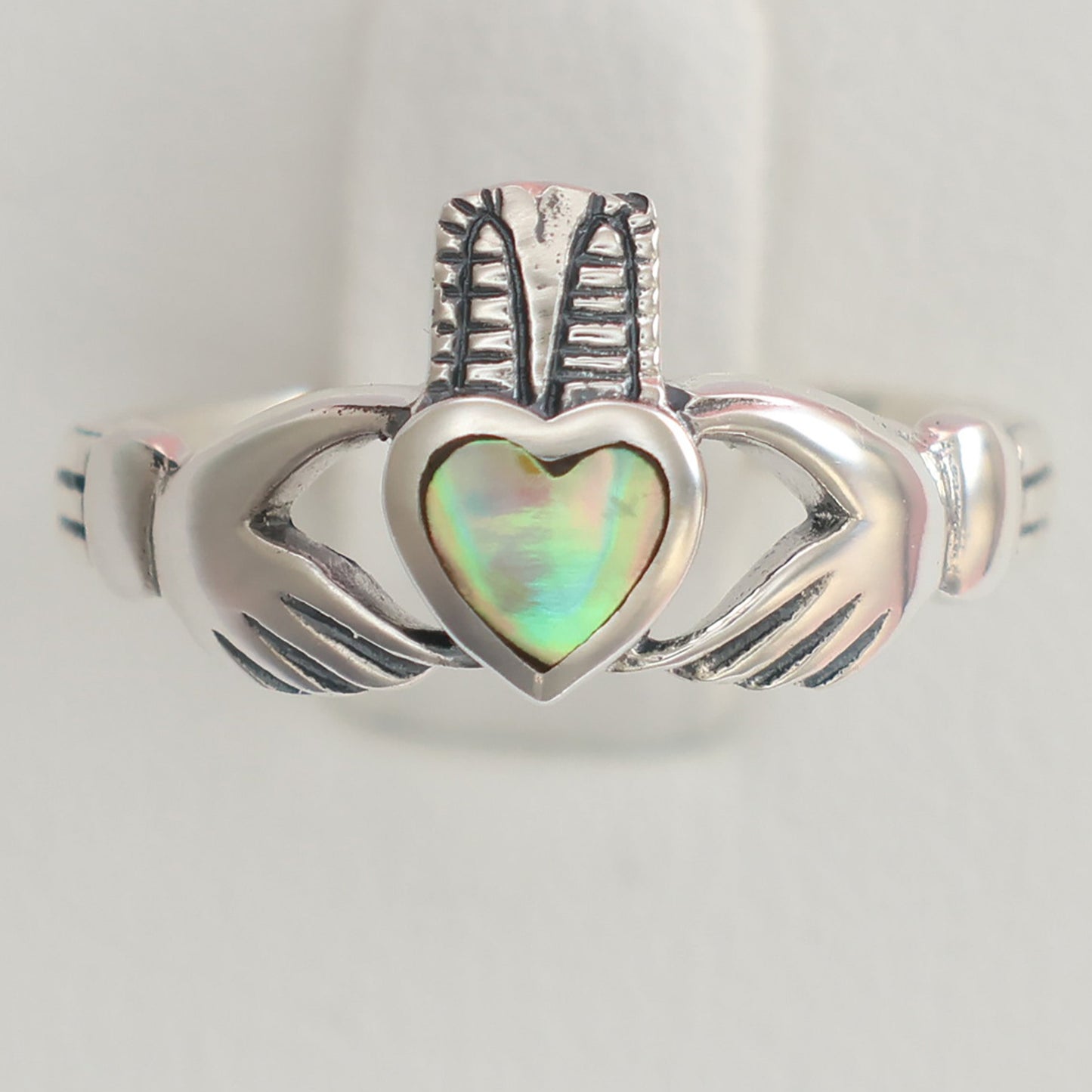 Silver Claddagh Ring with an iridescent heart stone and intricate hand design