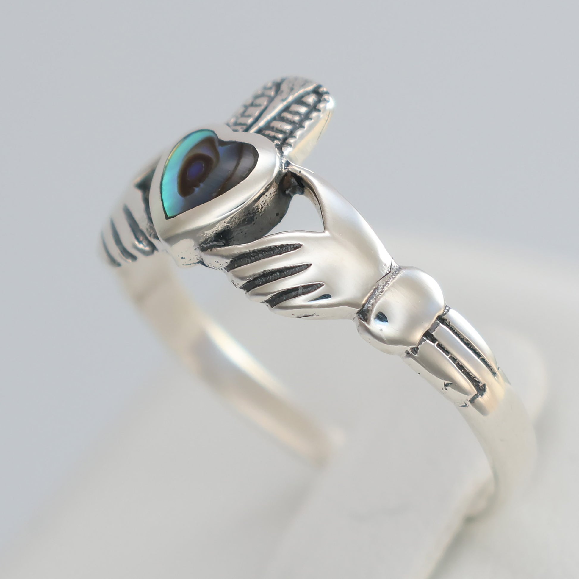 Elegant silver claddagh ring featuring a unique design and a gemstone centerpiece