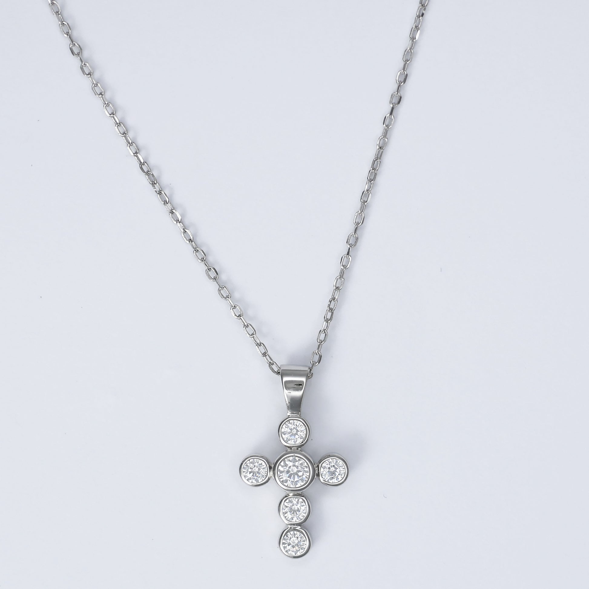 Elegant silver cross necklace for women adorned with sparkling stones on a delicate chain