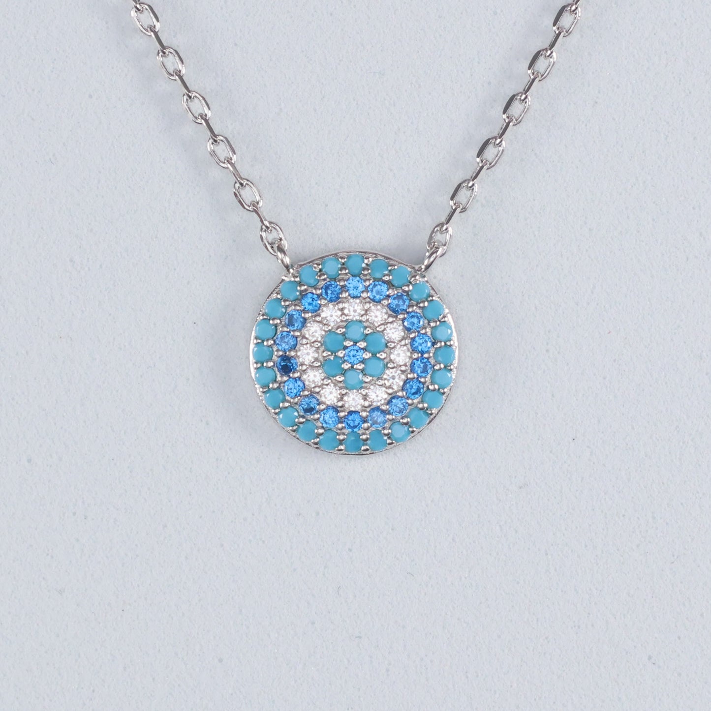 Silver Evil Eye Pendant with turquoise and white gemstones on a delicate chain