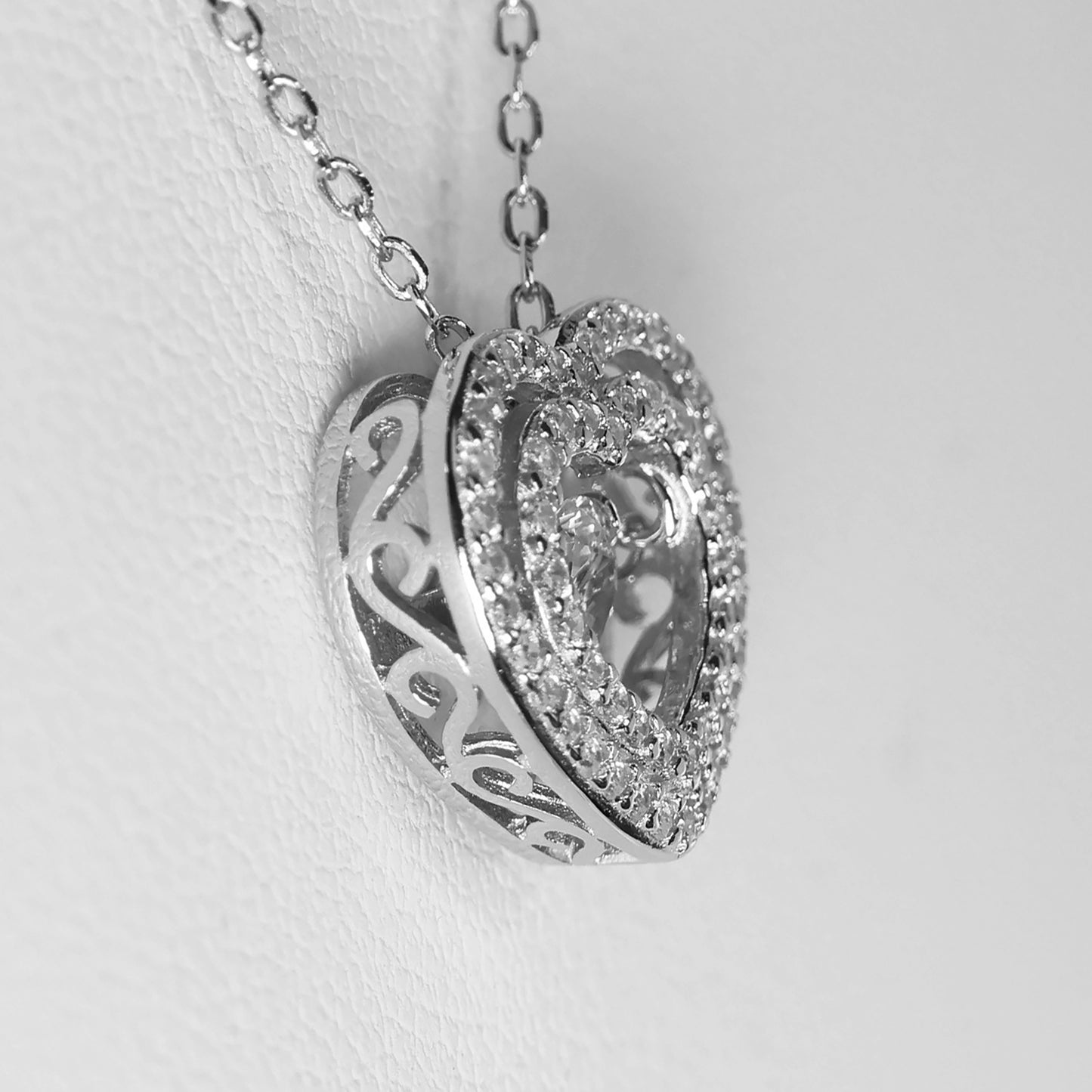 Elegant silver heart pendant necklace adorned with sparkling crystals and intricate detailing