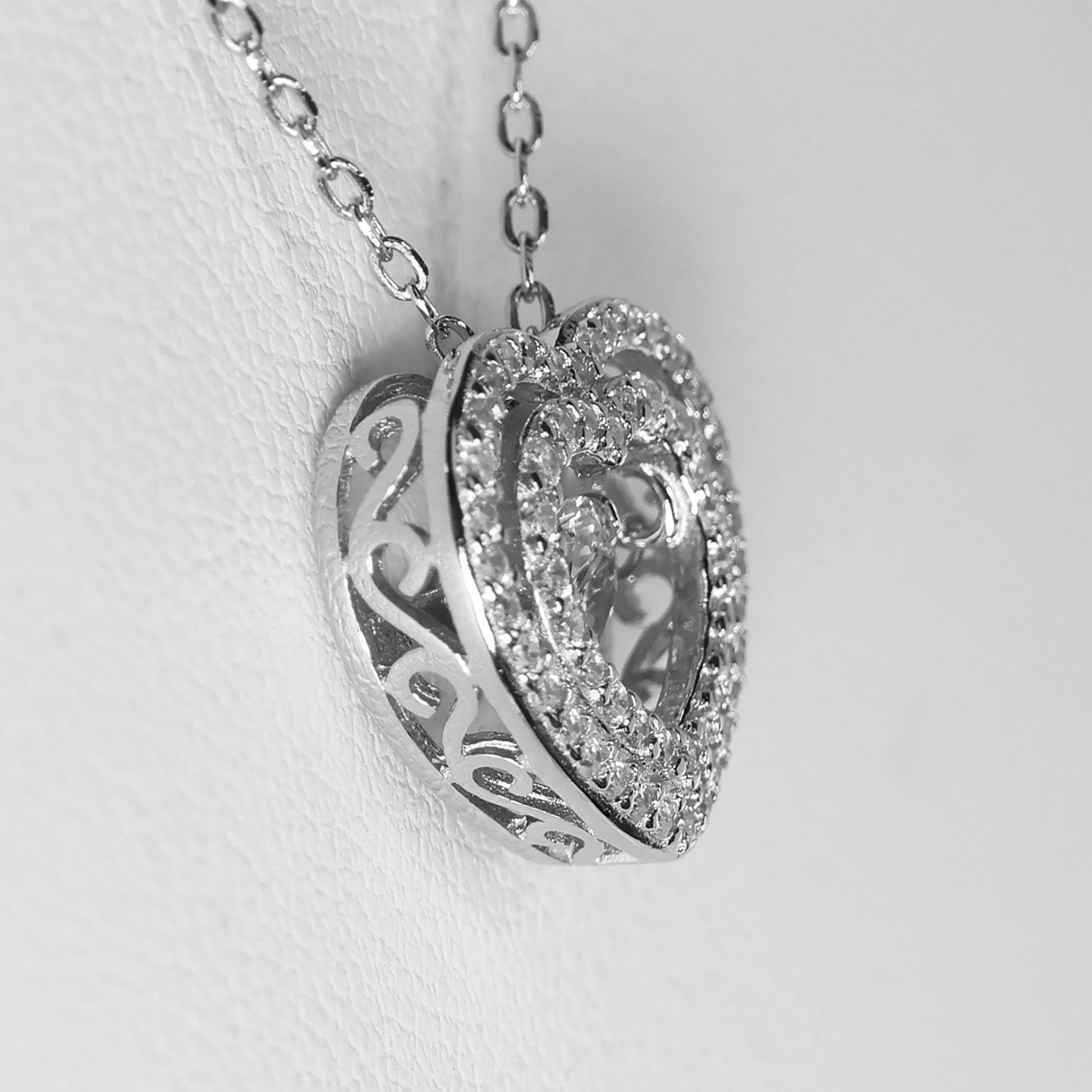Elegant silver heart pendant necklace adorned with sparkling crystals and intricate detailing