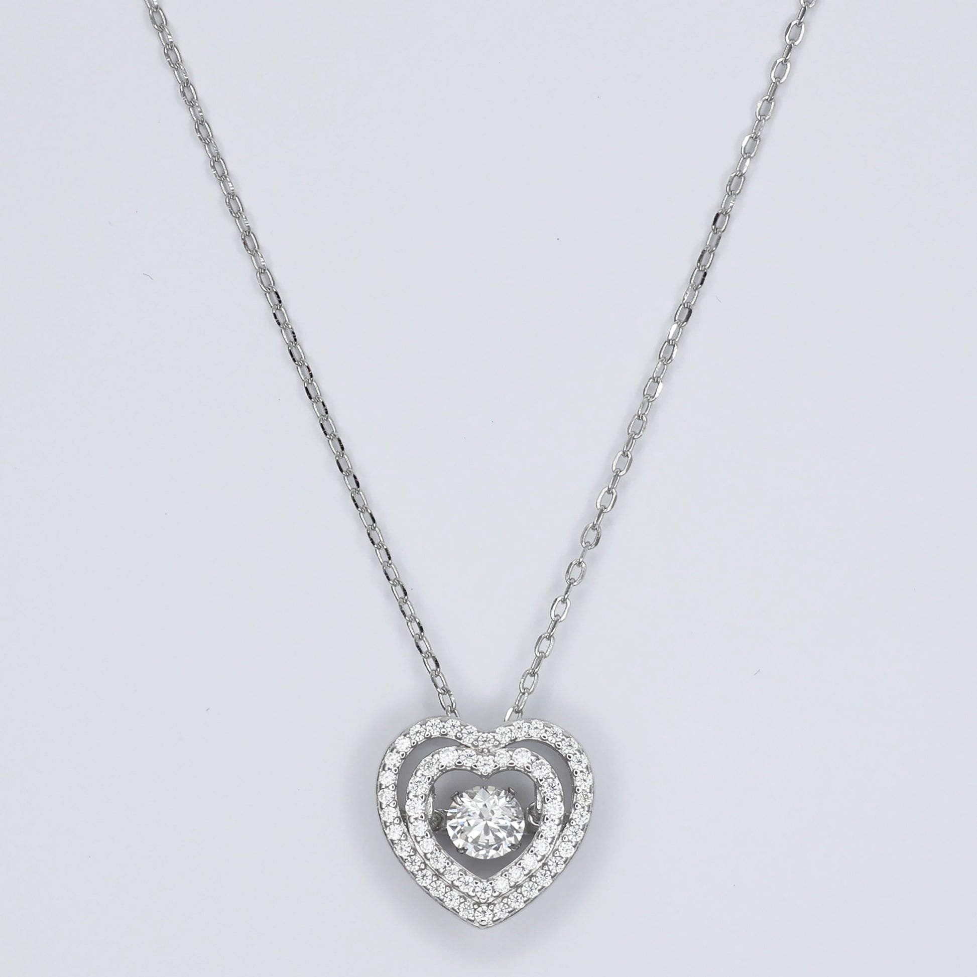 Elegant silver heart pendant necklace with sparkling center stone, perfect for romantic occasions
