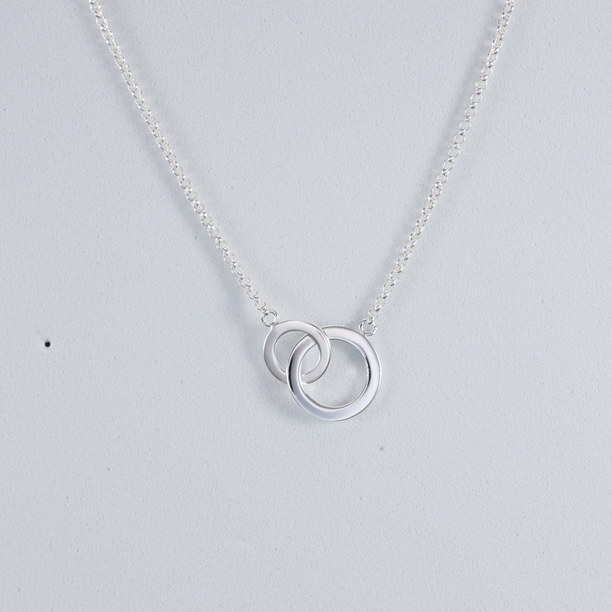 Elegant silver interlocking hoop necklace on a delicate chain, perfect for any occasion