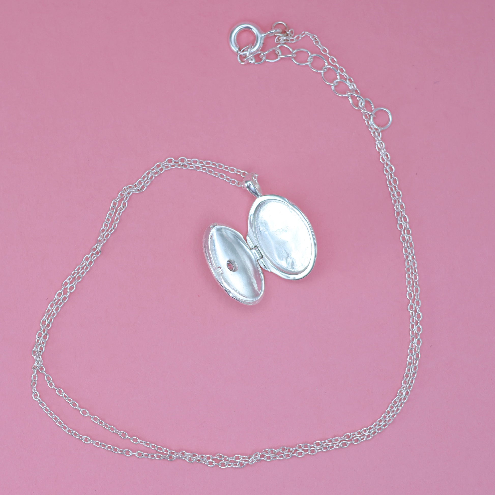 Silver oval locket necklace featuring an elegant design with an opening for cherished photos