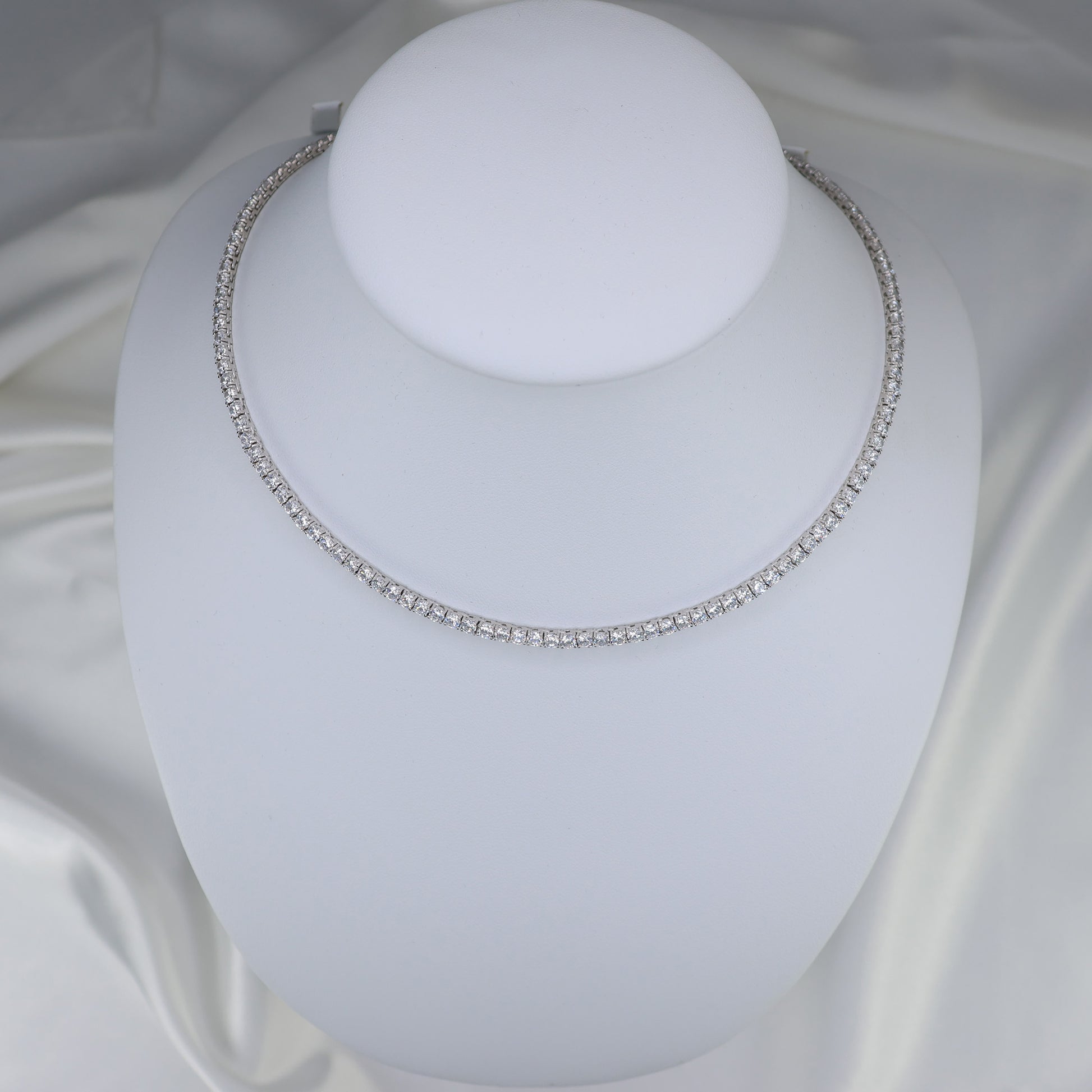 Elegant silver tennis necklace on display, featuring sparkling gemstones for a timeless look
